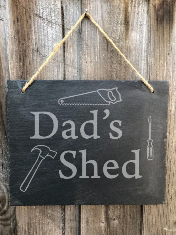 A sign that says dad 's shed with tools on it.