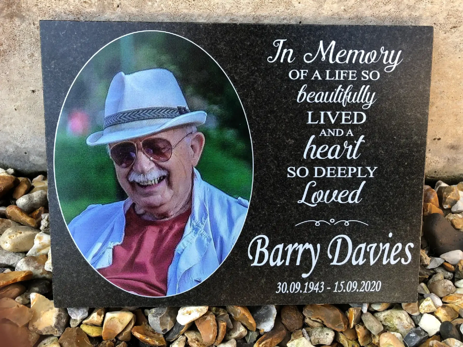 A memorial plaque with a picture of barry davies.