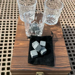 A wooden table with glasses and cubes of metal