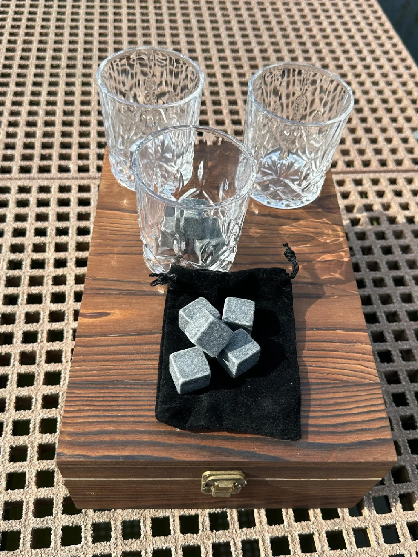 A wooden table with glasses and cubes of metal