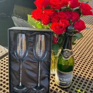 A bottle of wine and two champagne glasses on the table.