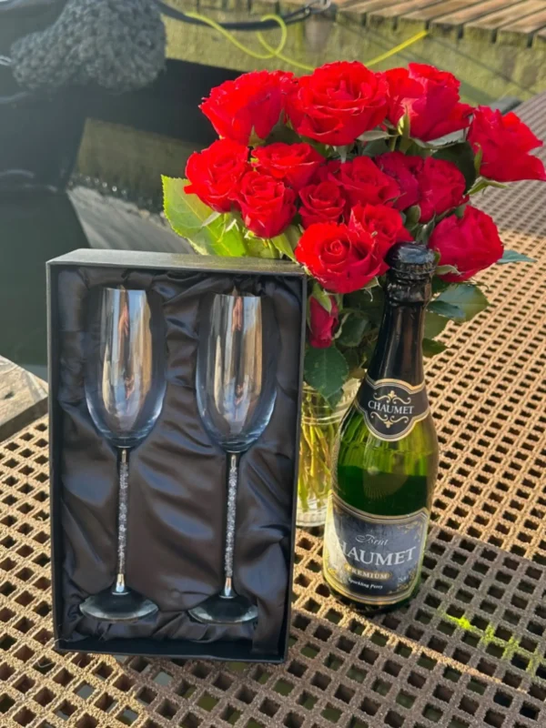 A bottle of wine and two champagne glasses on the table.