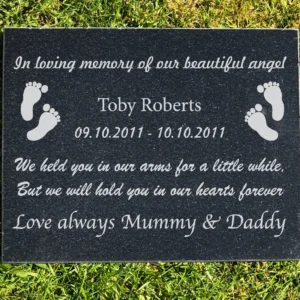 A memorial plaque with footprints and the words " in loving memory of our beautiful angel ".