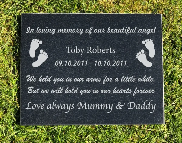 A memorial plaque with footprints and the words " in loving memory of our beautiful angel ".