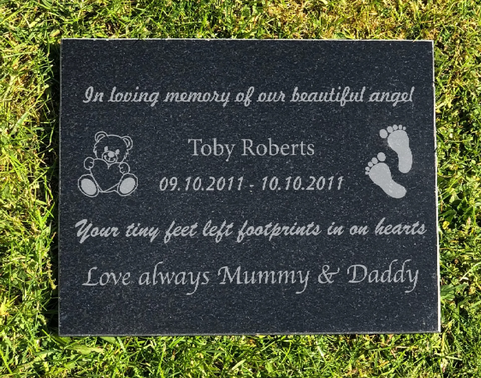 A memorial plaque with the name of a child and date.