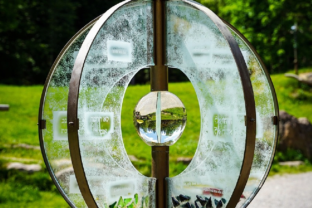 A glass sculpture of an eye with grass in the background.